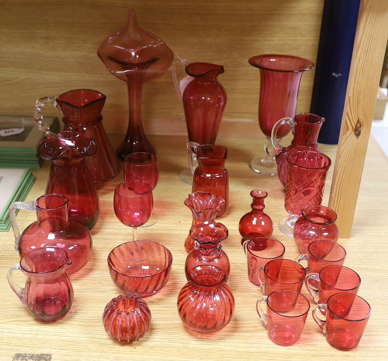 Cranberry glassware including vases, jugs, bowls and custard cups, the largest 33cm high